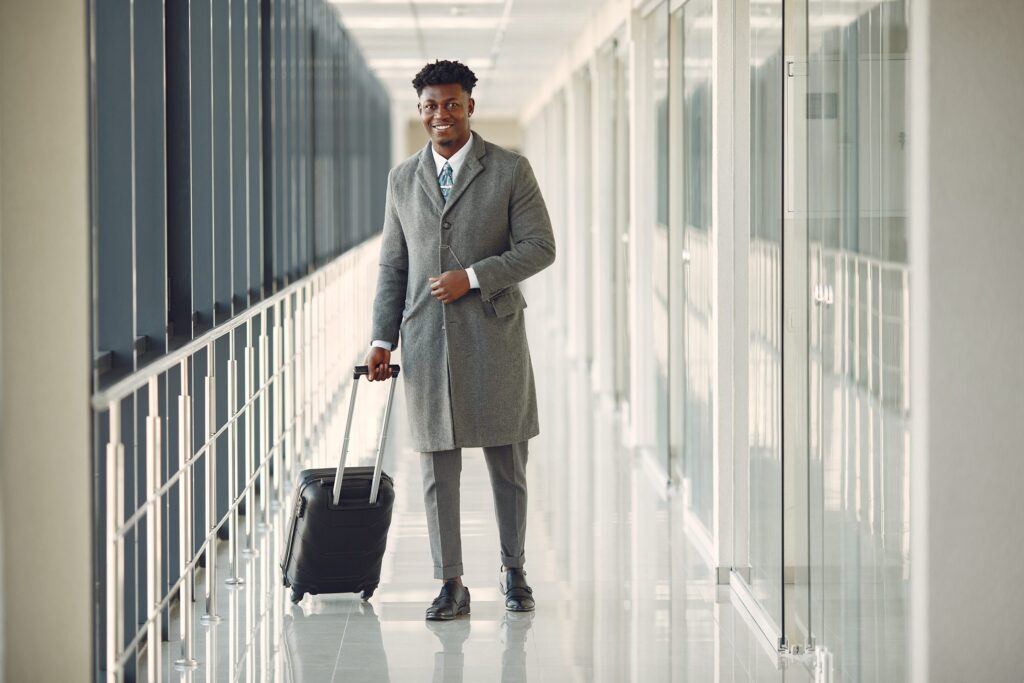 elegant-black-man-airport-with-suitcase-scaled